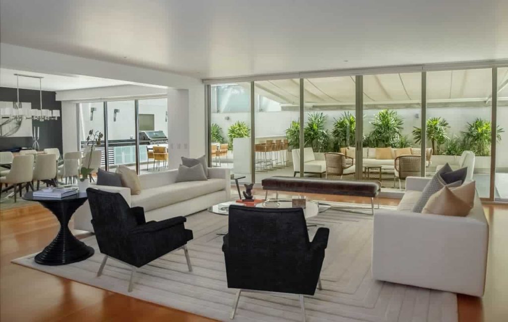 A living room with large windows and white furniture in a Hamilton property managed by professional services.