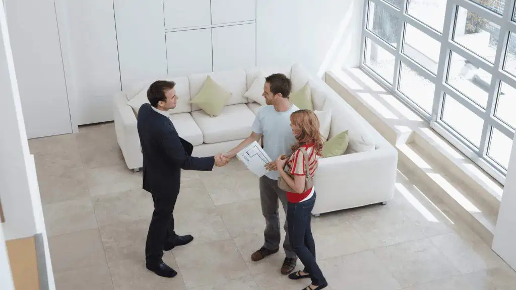 Two individuals engaging in a handshake gesture inside a living room as a symbol of collaboration and mutual trust in the context of property management.