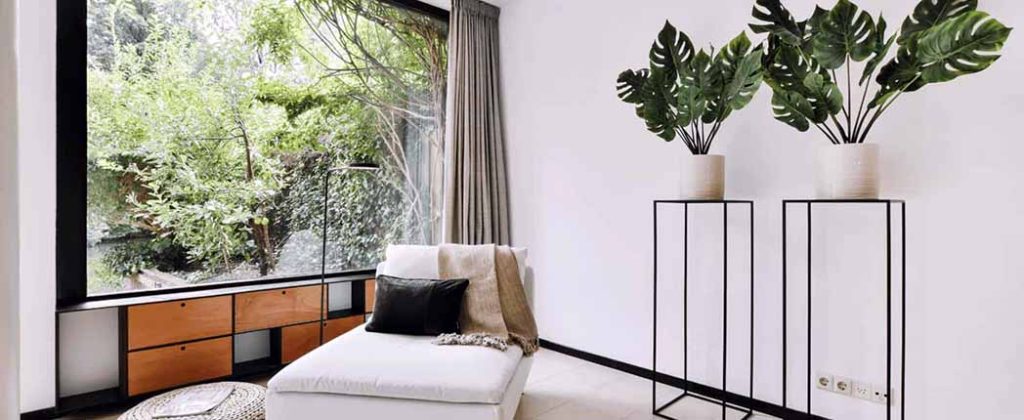 Bright and minimalist interior with a chaise lounge, potted plants, and a garden view, streamlining property management, Landlord FAQ, canadian property management