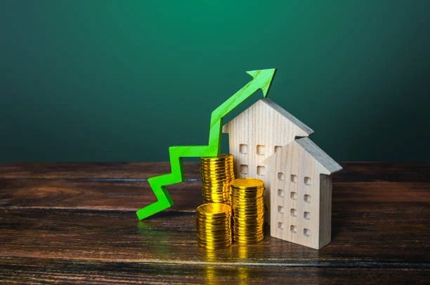 A model of a house showcasing the return on investment (ROI) for property investment, represented by coins and a green arrow.