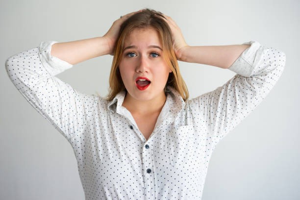 A young woman experiencing Property Management Challenges with her hands on her head, residential property management Hamilton