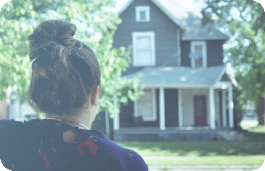 A woman standing in front of a house, managing your rental property.