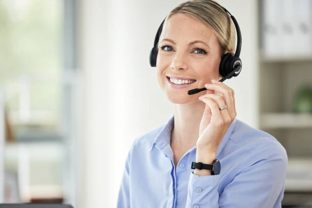 A woman wearing a headset and working in front of a laptop is providing customer service for a Property Management Company.