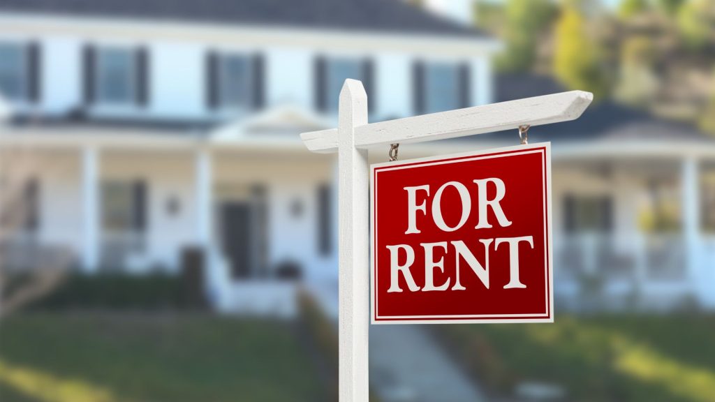 A for rent sign in front of a house advertised as a Short Term Rental.
