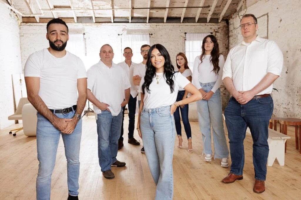 A group of people from apartment management companies standing in a white room.