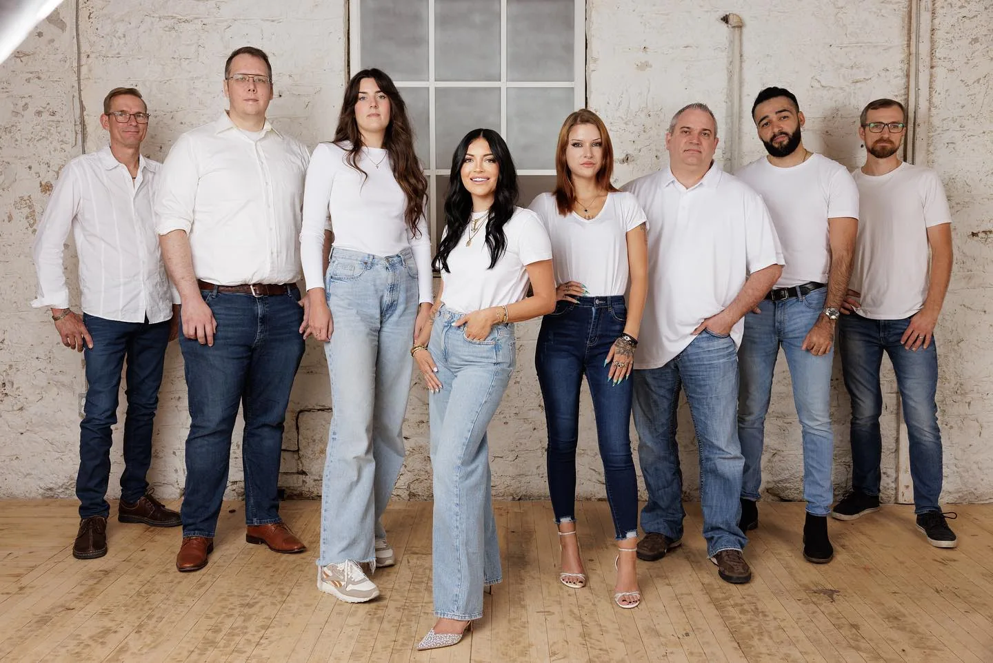 A group of people in white shirts posing for a photo at property management company