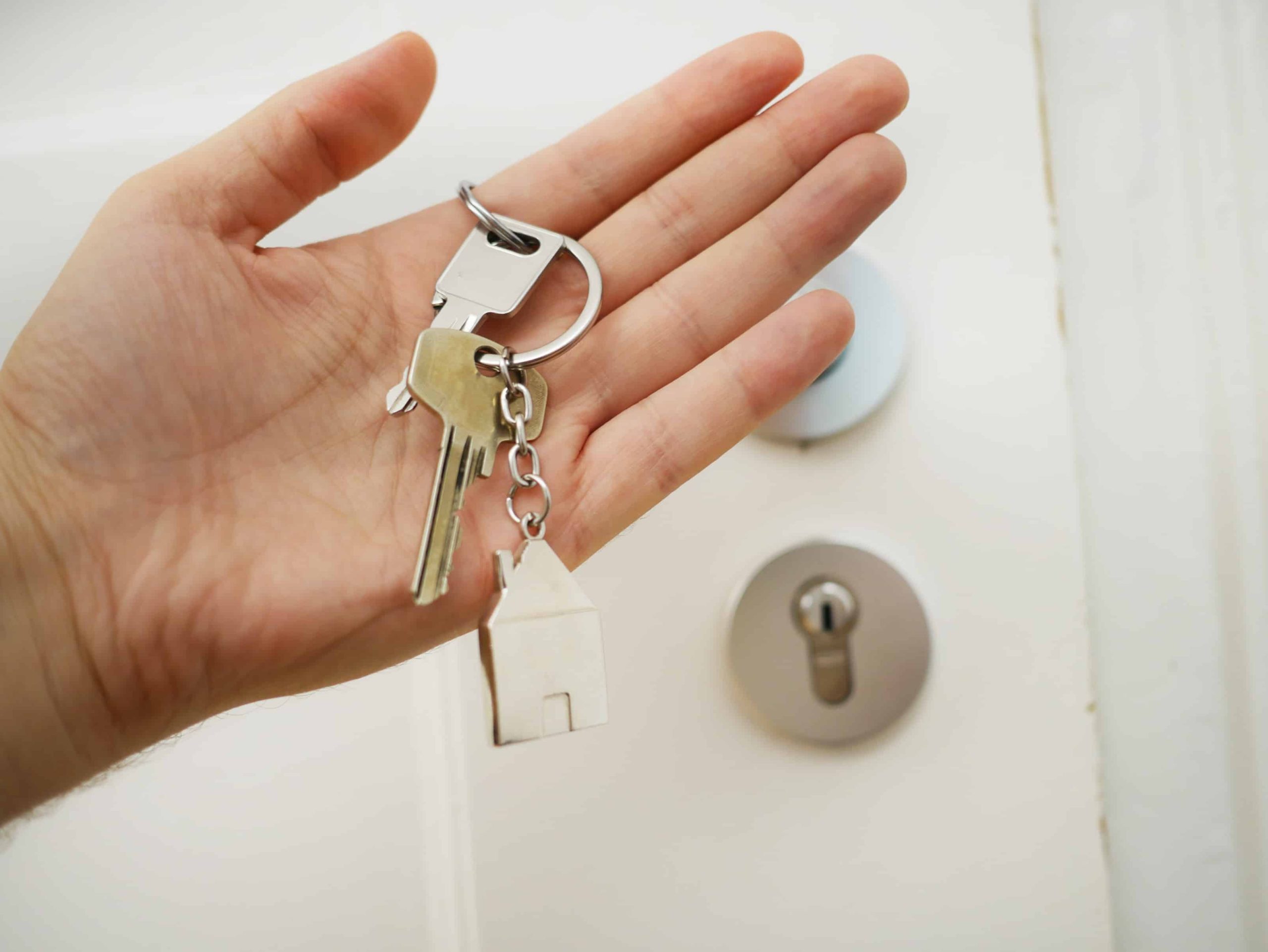 A person holding a key to a house in front of a door, Tenants Welcome Package