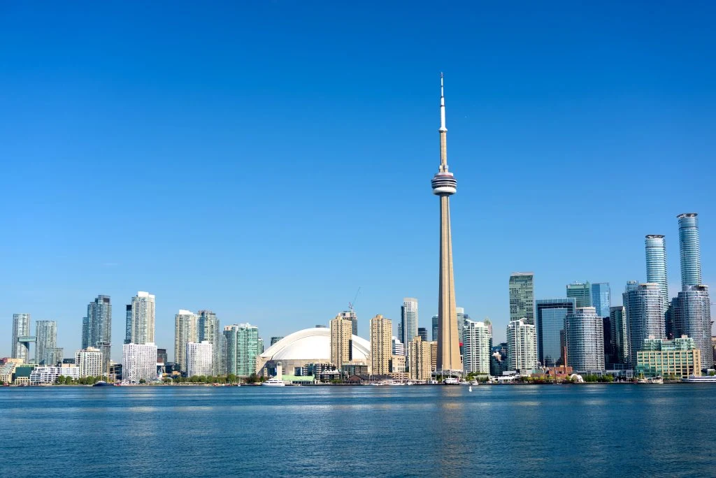 Toronto city skyline with the CN Tower and surrounding skyscrapers on a clear day, viewed across the water, highlights the vibrant rental market amidst the bustling urban landscape.