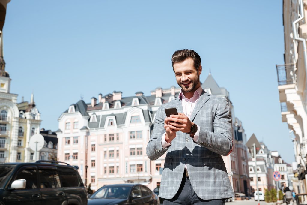 portrait young man jacket using mobile phone
